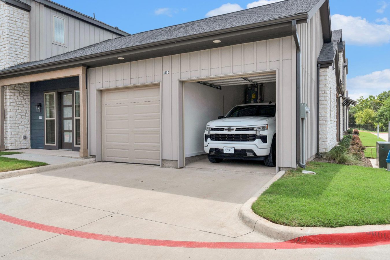 a white truck is parked in front of a garage at The parcHAUS at Celina Parkway