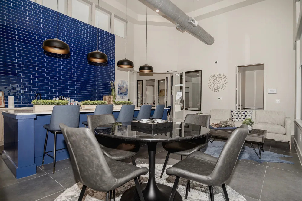 the dining room has blue tile walls and a black table at The parcHAUS at Celina Parkway