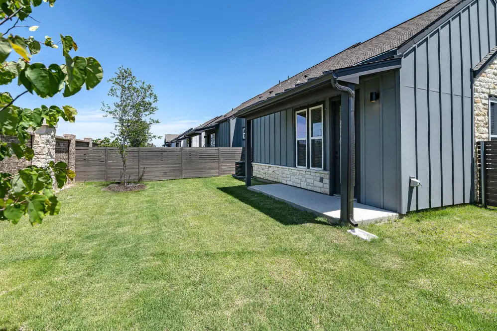 a home with a yard and grass at The parcHAUS at Celina Parkway